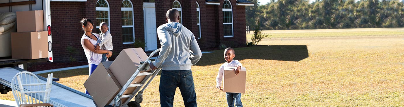 Family putting boxes into moving van