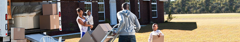 Family putting boxes into moving van