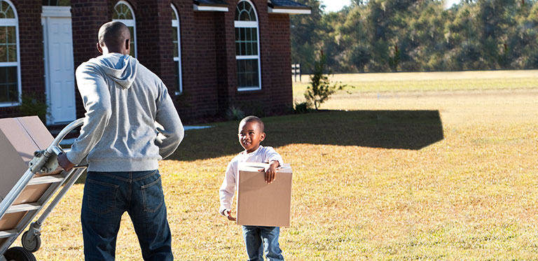 Family putting boxes into moving van