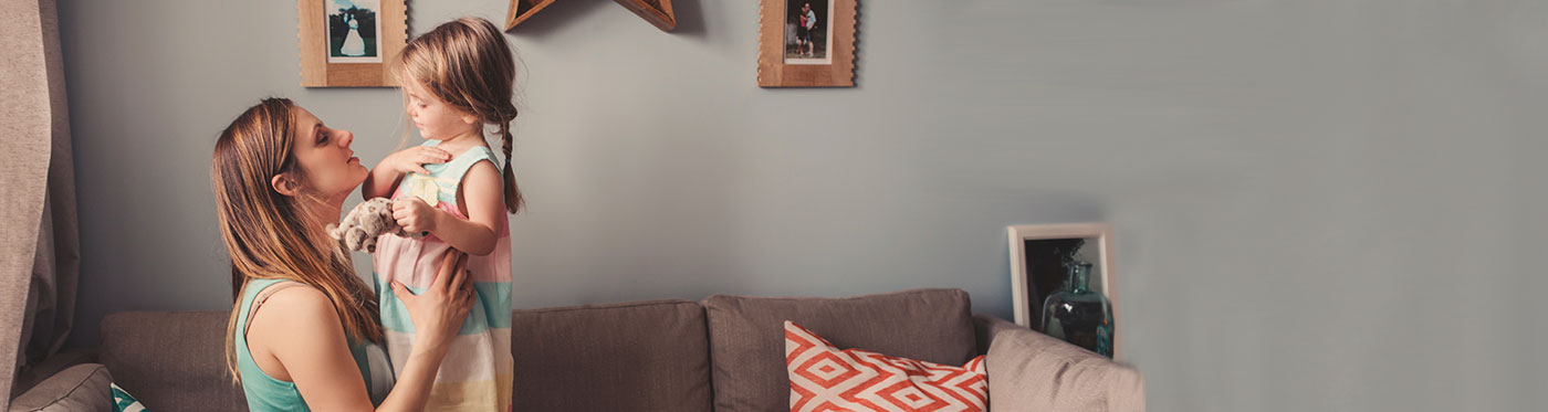 mother and toddler daughter playing on the couch