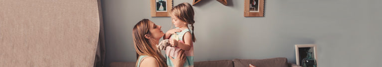 mother and toddler daughter playing on the couch